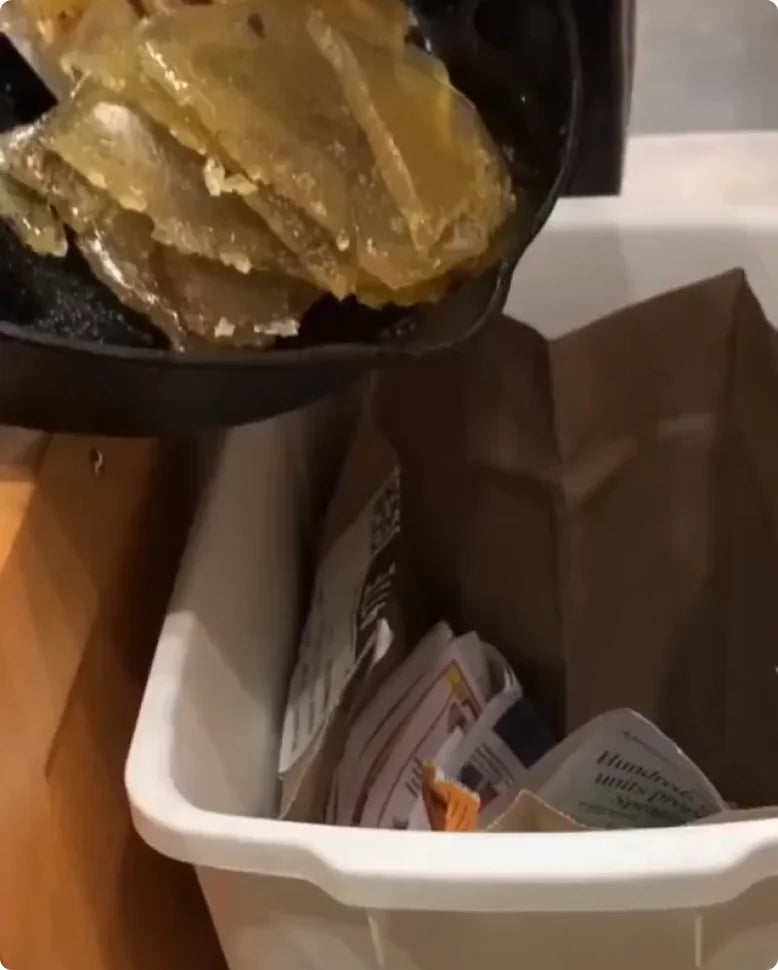 Solidified oil being scooped into the trash